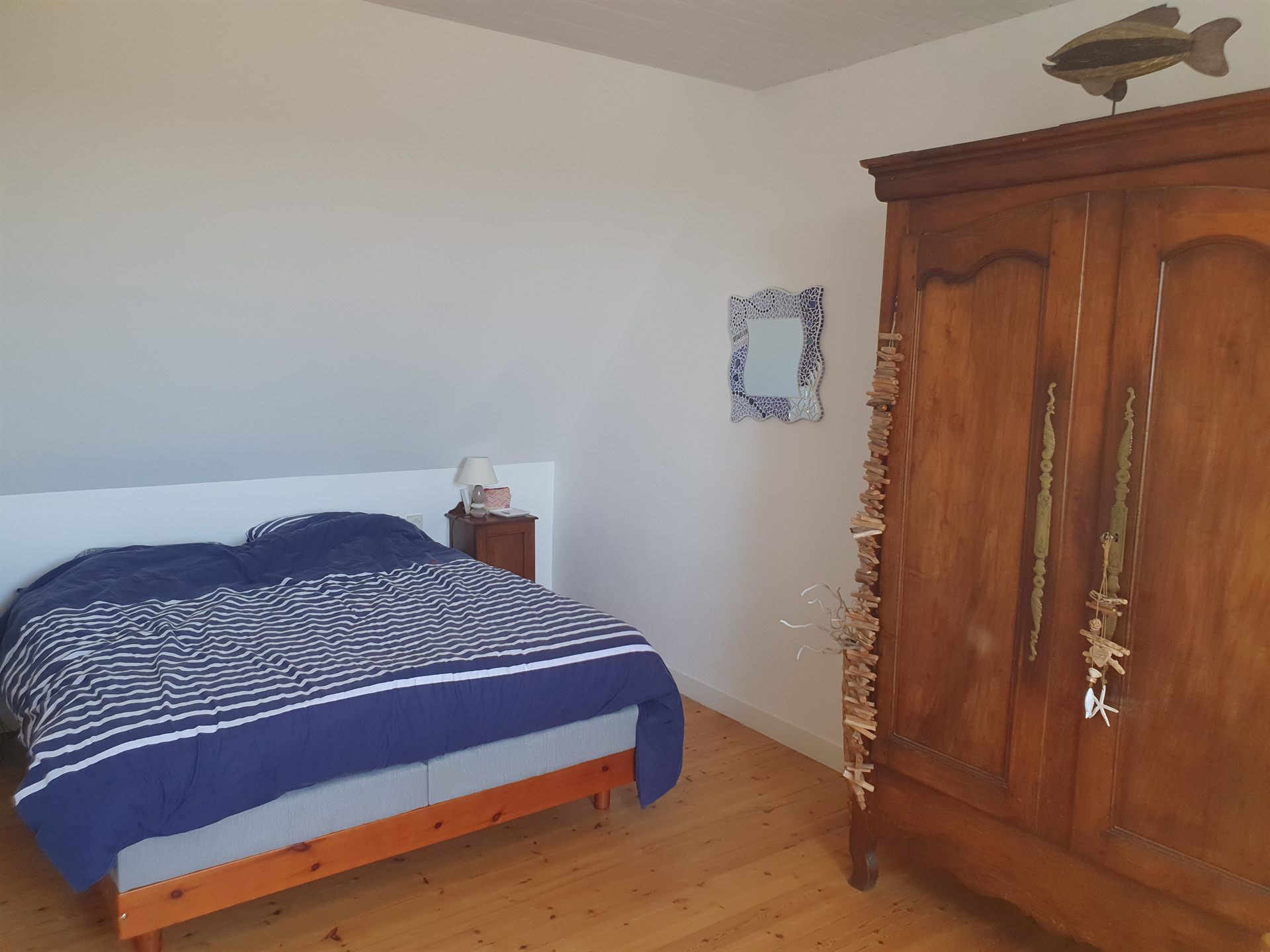 Schlafzimmer mit Doppelbett im maritimen Stil, Holzboden