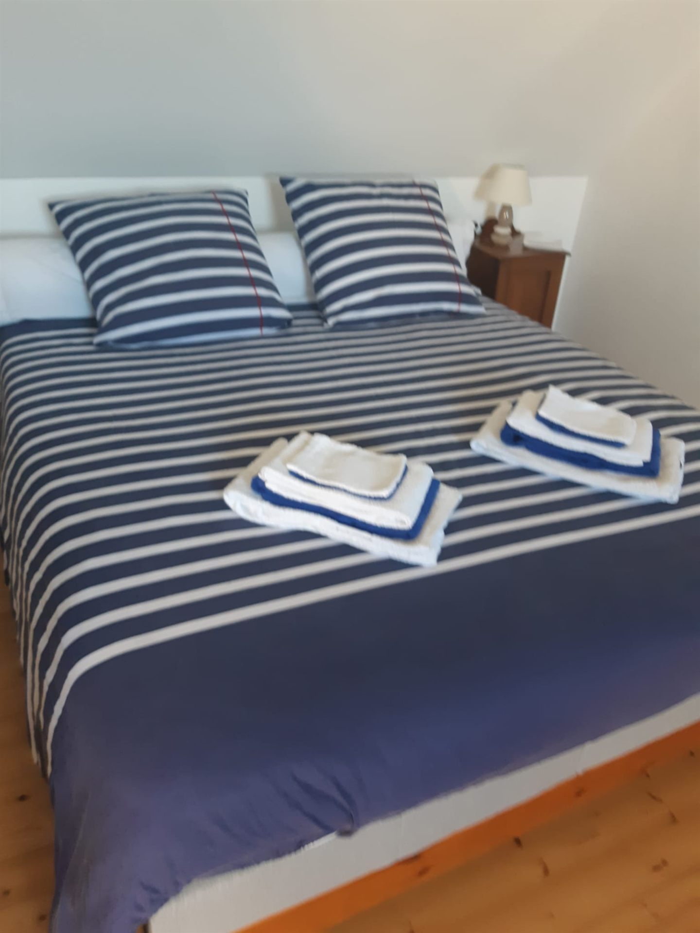 Schlafzimmer mit Doppelbett und bereitgestellter marineblauer Wäsche