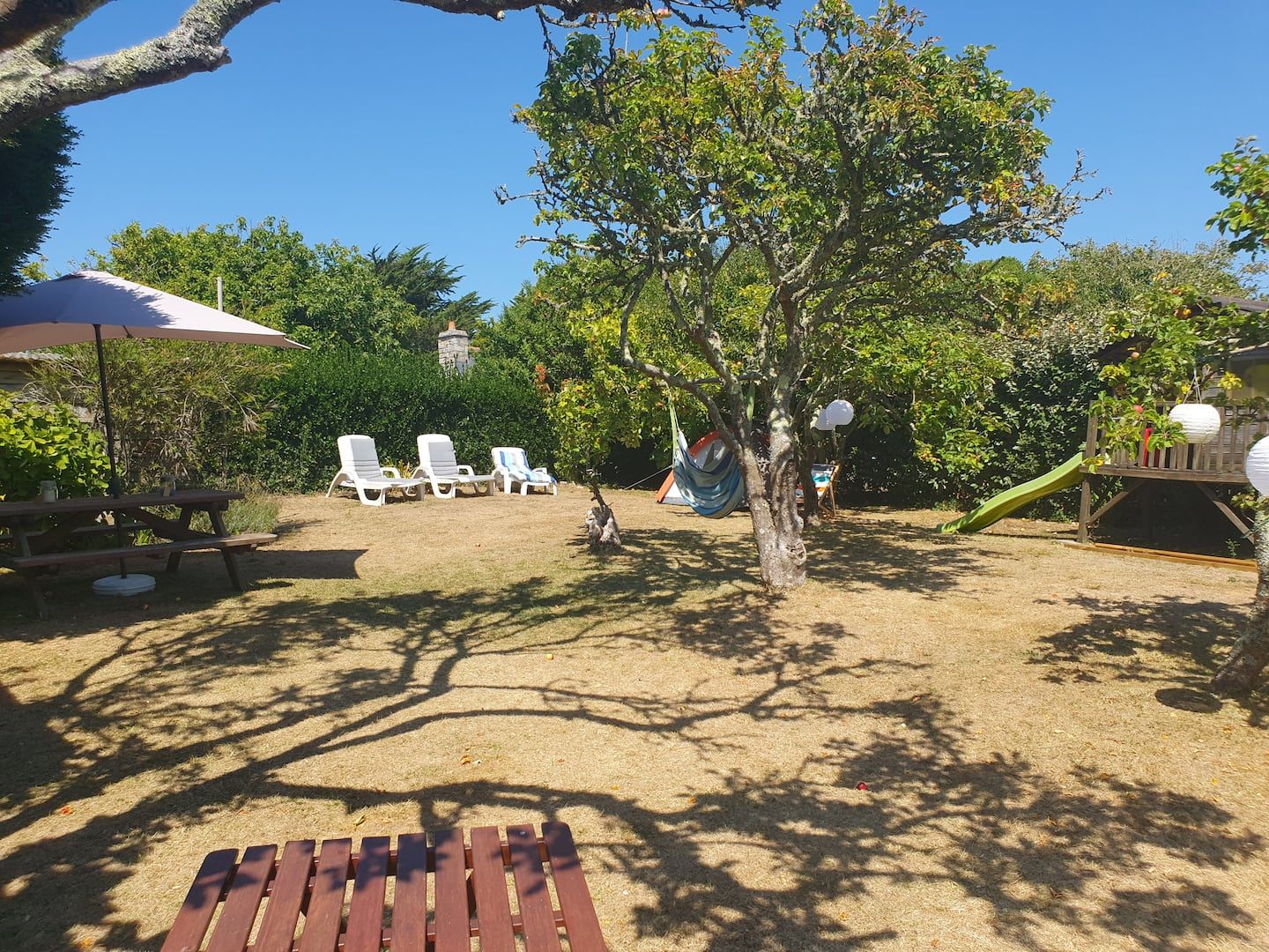 Umzäunter Garten von 500 m² mit Sonnenschirm und Liegestühlen, nicht einsehbar