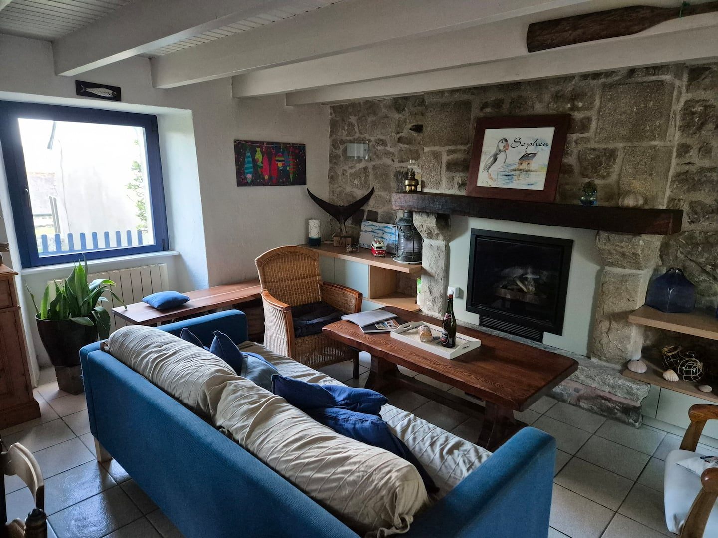 Helles Wohnzimmer mit blauem Sofa und Fernsehecke